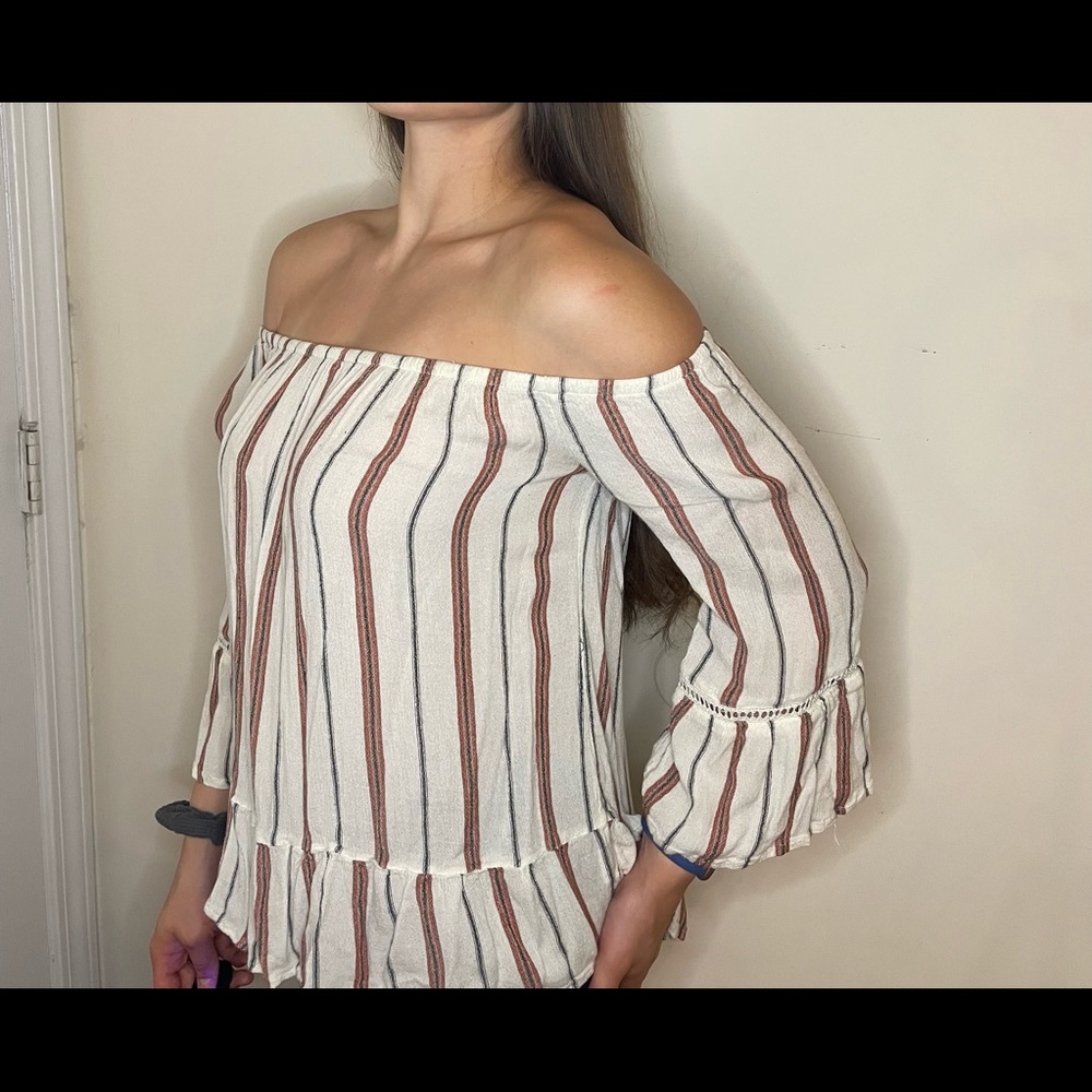 An off the shoulder cream top with red and black pattern